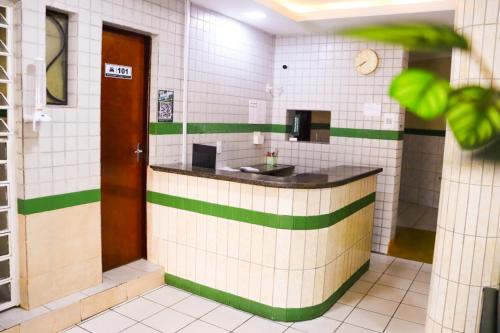 a bathroom with a sink in a white tiled wall at Pousada Dom Manuel - Ce in Fortaleza