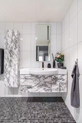 a white bathroom with a sink and a mirror at Apartment in the heart of Bergen in Bergen