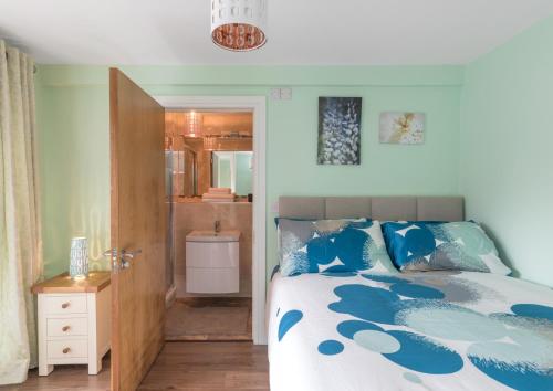 a bedroom with a blue and white bed and a bathroom at Spacious 2-Bedroom Apartment near O'Connell St in Dublin