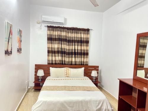 a bedroom with a bed and a window and a mirror at LeLodge Djibouti in Djibouti