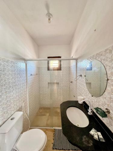 a bathroom with a toilet and a sink and a mirror at Casa da Juma in Fortim