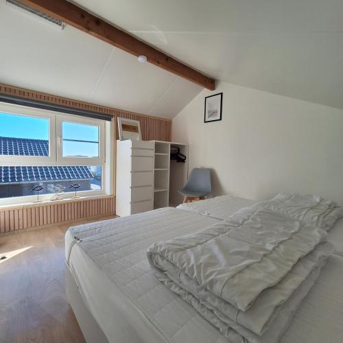 a bedroom with a large bed and a window at Maison Maritime in Middelkerke