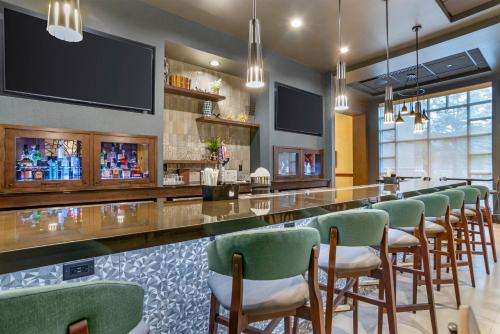 a bar with green chairs and a long counter at Drury Inn & Suites Baton Rouge in Baton Rouge