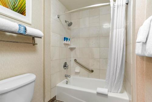 a bathroom with a white toilet and a shower at Drury Inn & Suites Baton Rouge in Baton Rouge