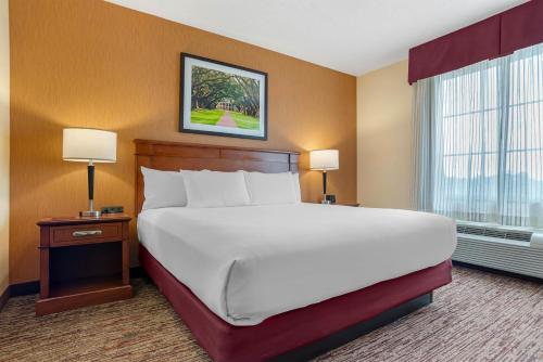 a large bed in a hotel room with two lamps at Drury Inn & Suites Baton Rouge in Baton Rouge