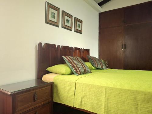 a bedroom with two beds with green sheets and a wooden headboard at Green Park Urbarí in Santa Cruz de la Sierra
