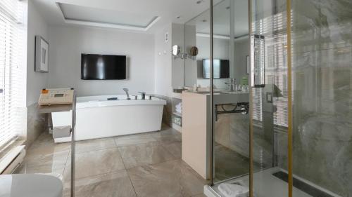 a bathroom with a bath tub and a sink at Hôtel Palace Royal Centre-Ville Québec par JARO in Quebec City