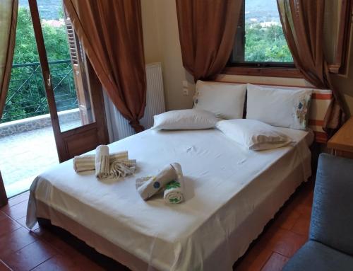 a bedroom with a large white bed with a window at Villa Evi in Volos