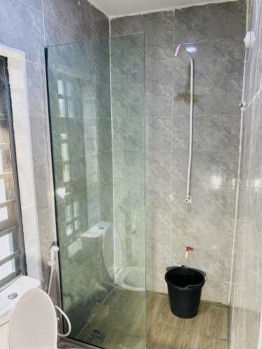 a bathroom with a shower with a glass door at Wesmont Hotels in Ikorodu