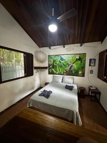 a bedroom with a bed and a ceiling fan at Mono Azul Cahuita in Cahuita