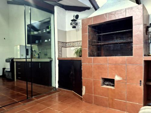 a kitchen with a large brick fireplace in a room at Green Park Urbarí in Santa Cruz de la Sierra