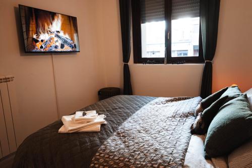 a bedroom with a bed with a tv on the wall at Alpine Green Apartment 2026 in Sondrio