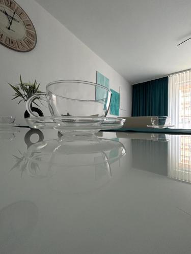 a glass table with a clock on the wall at Apartament Dobrzec in Kalisz