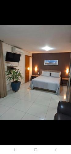 a bedroom with a bed and a flat screen tv at Crystal Place Flat 509 in Goiânia