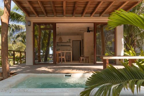 a villa with a swimming pool in front of a house at Hábitat Nandá in La Manzanilla