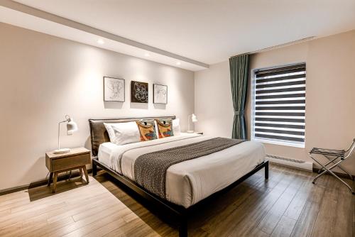 a bedroom with a large bed and a window at 77 St-Vallier Apparts Hôtel in Quebec City