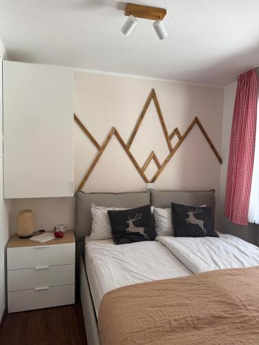 a bedroom with a bed with a woodenabaligned headboard at Allgäutraum in Bolsterlang