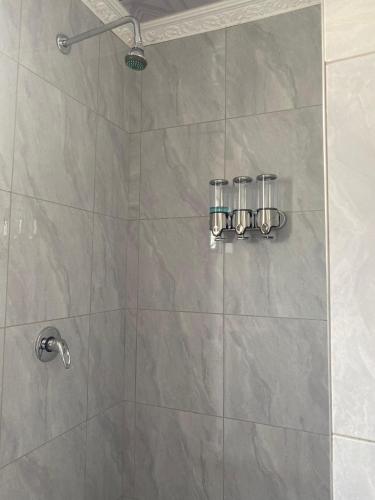 a shower stall with two glasses on the wall at Namhla Guest House in Nongoma