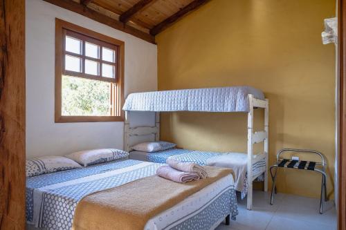 two bunk beds in a room with a window at Milho Ventura II, Vila Pôr do Sol in Sêrro