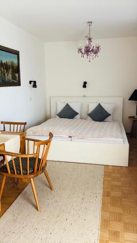 a bedroom with a bed and a chair and a chandelier at Ferienwohnungen an der RupertusTherme in Bad Reichenhall