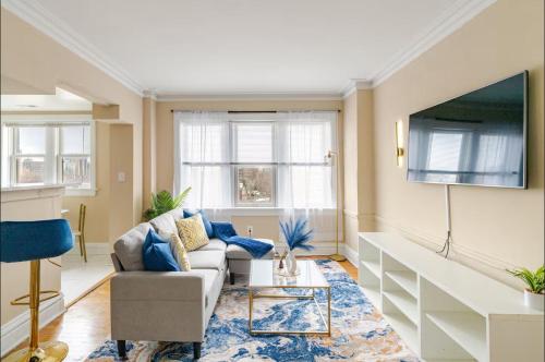 a living room with a couch and a tv at The Cozy Luxe Retreat, Central West End in Saint Louis