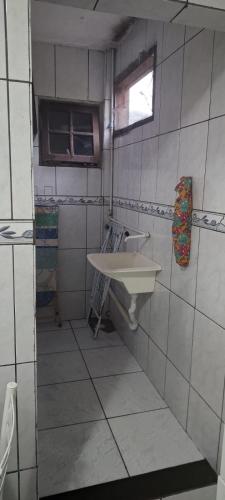 a small bathroom with a sink and a window at Casa Ampla Vila Muriqui in Vila Muriqui
