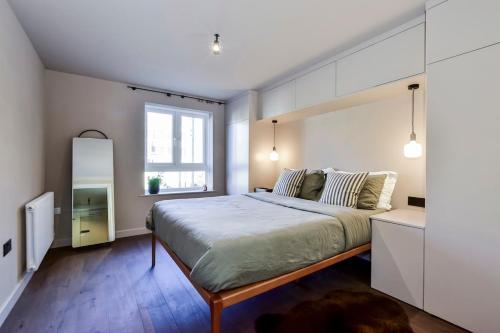 a bedroom with a large bed and a window at Luxury 2 bed canal side apartment near Kings Langley station & Warner Brother Studios in Kings Langley