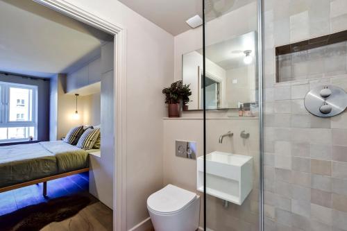 a bathroom with a shower and a toilet and a bed at Luxury 2 bed canal side apartment near Kings Langley station & Warner Brother Studios in Kings Langley