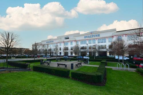 a large building with benches in front of it at Luxury 2 bed canal side apartment near Kings Langley station & Warner Brother Studios in Kings Langley