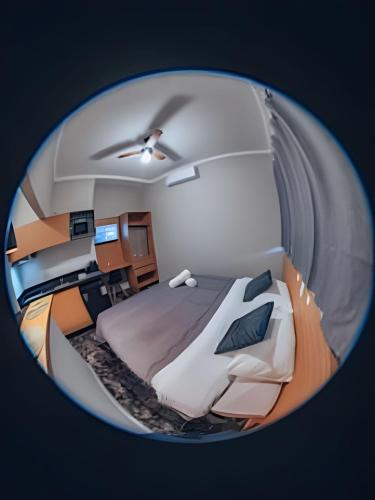 a round room with a bed and a desk at Zuccaro Studio in Bauru