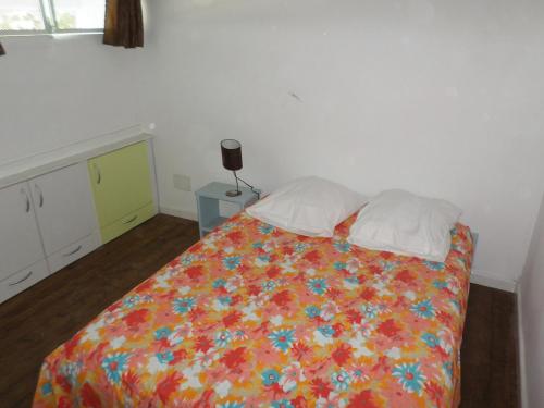 a bedroom with a bed with a colorful blanket and pillows at Villa Barboteau in Port-Louis