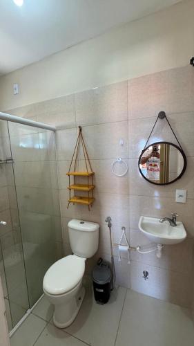 a bathroom with a toilet and a sink and a mirror at Dunas Exclusive in Santo Amaro