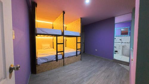 a room with two bunk beds with purple walls at Shambala Hostel in Huacachina