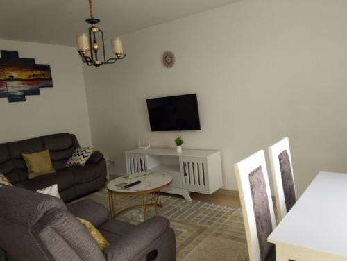 a living room with a couch and a tv at Unity Homes Eldoret in Eldoret
