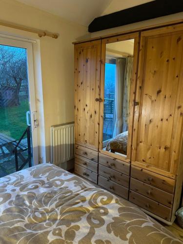 a bedroom with a large wooden cabinet and a bed at Derbyshire Holiday Cottages in Holmesfield