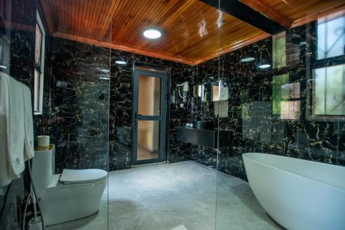 a bathroom with a tub and a toilet and a sink at Cozy Stead Hotel - Haven House, Gigiri in Nairobi