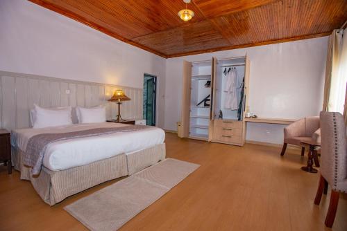 a bedroom with a large white bed and a chair at Cozy Stead Hotel - Haven House, Gigiri in Nairobi