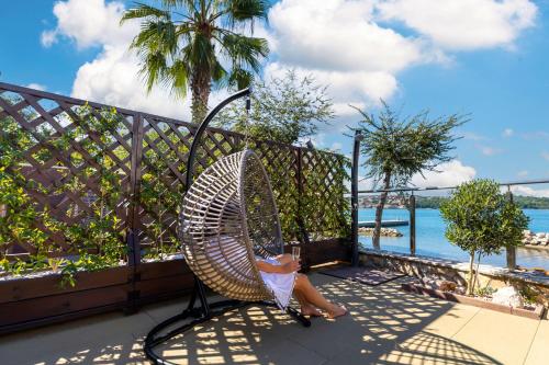 a little girl sitting in a chair on a balcony at Soline Bay Seashore Residence in Soline