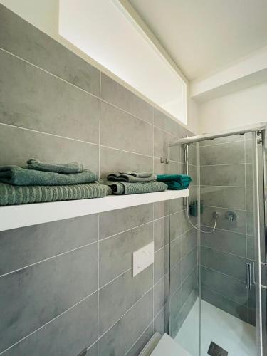 a bathroom with a shower and some towels on a shelf at Dolce Hogar Residence in Chiavari