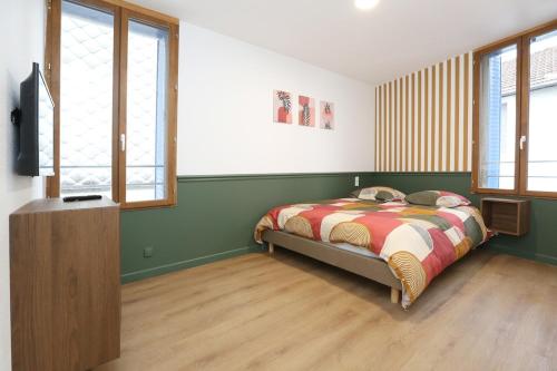 a bedroom with a bed and a flat screen tv at Superbe appartement avec écran géant in Tarbes