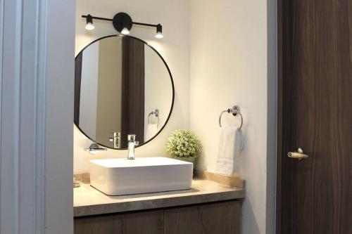 a bathroom with a white sink and a mirror at Charming Suite Pool AC Location 10C in San Pablo