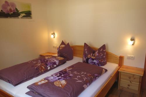 ツェル・アム・ツィラーにあるFerienwohnung Kainerのベッドルーム(紫色の掛け布団付きベッド2台付)