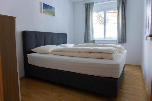 a bed with white sheets and pillows in a bedroom at Casa Carinthia in Samnaun