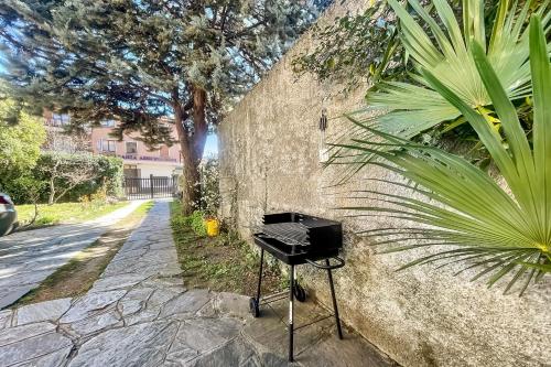 a black grill sitting on a sidewalk next to a wall at Menaggio 57 in Menaggio