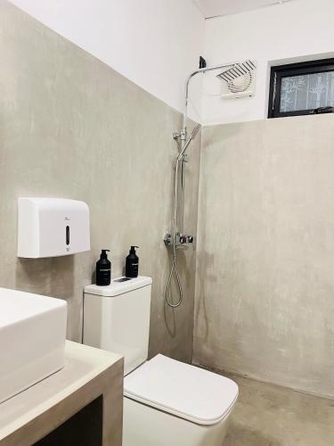 a bathroom with a white toilet and a shower at La Manga Mirissa in Mirissa