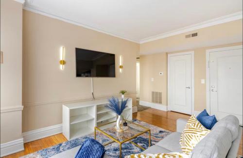 a living room with a couch and a tv at The Cozy Luxe Retreat, Central West End in Saint Louis