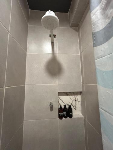 a bathroom with a shower with two pairs of shoes at Mini Suite Sossego in Garanhuns