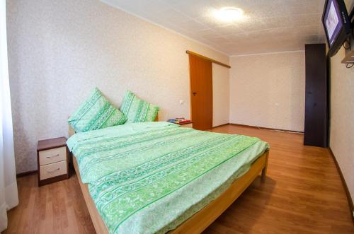 a bedroom with a bed with a green comforter at VIP apartment on 14 Vidradnyi Avenue in Kyiv