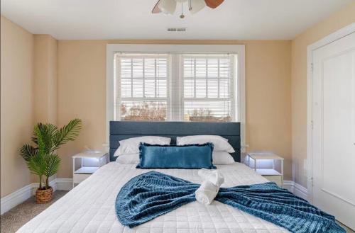 a bedroom with a large bed with a blue pillow at The Cozy Luxe Retreat, Central West End in Saint Louis