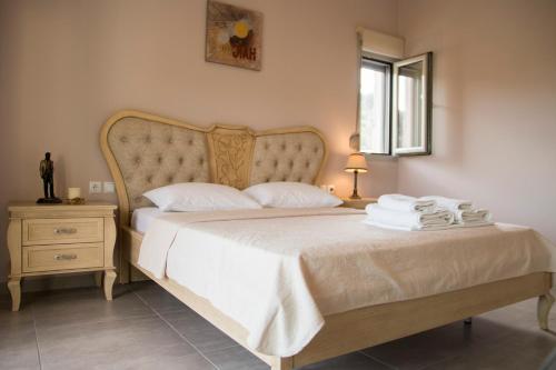 a bedroom with a large bed with white sheets at Pargamaisonnette in Parga
